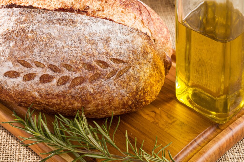 Pão artesanal servido com azeite e alecrim, imagem ilustrativa