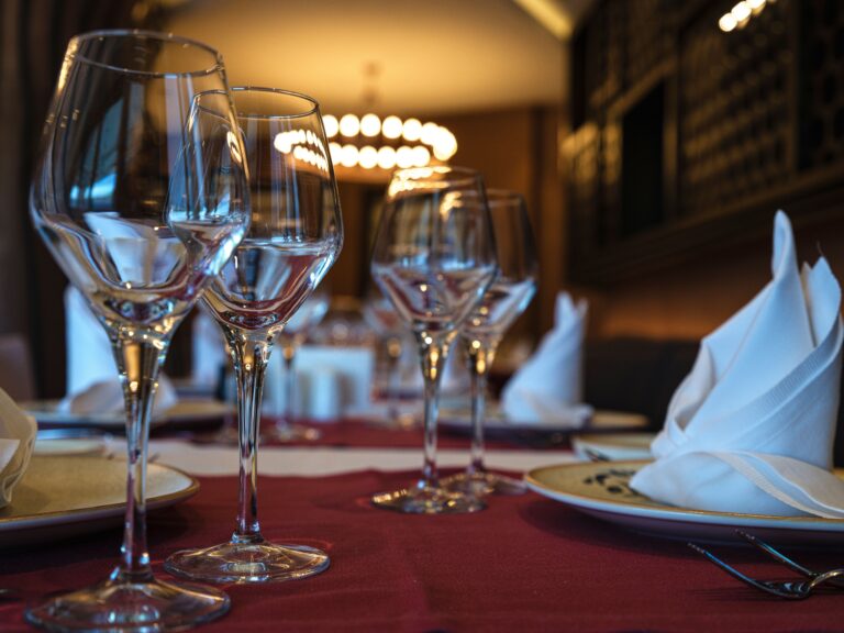 Mesa de restaurante preparada com taças e guardanapos, imagem ilustrativa