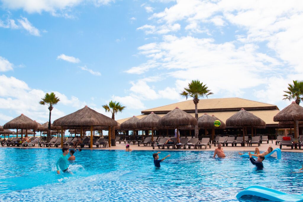 Famílias em piscina de resort tropical, imagem ilustrativa