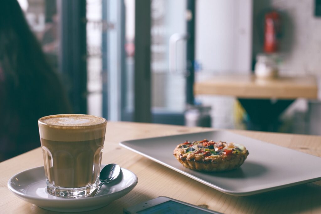Café e refeição em mesa, imagem ilustrativa dos gastos com alimentação em uma viagem a Holambra