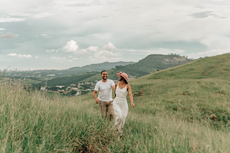 Casal caminhando em paisagem verde de montanha, imagem ilustrativa de viagem na primavera